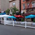 outdoor seating with white picket fence on arthur ave